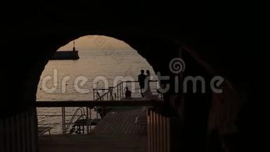 在拱门上，新娘和新郎在海的背景下的剪影